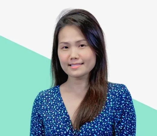 Smiling woman in a blue polka-dot dress against a light background with a green triangular design.